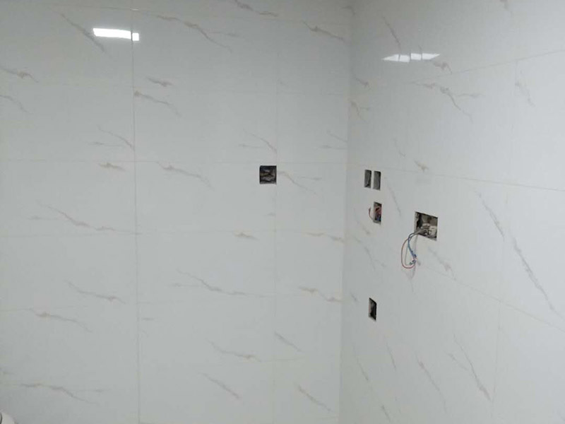 衛(wèi)生間瓷磚鋪貼：基層處理：把沾在基層上的浮漿、落地灰等用暫子或鋼絲刷清理掉，再用掃帚將浮土清掃干凈。找標高：根據(jù)水平標準線和設(shè)計厚度，在四周墻、柱上彈出面層的上平標高控制線。排磚：將房間依照磚的尺寸留縫大小，排出磚的放置位置，并在基層地面彈出十字控制線和分格線。鋪設(shè)結(jié)合層砂漿：鋪設(shè)前應將基底濕潤，并在基底上刷一道素水泥漿或界面結(jié)合劑，隨刷隨鋪設(shè)攪拌均勻的干硬性水泥砂漿。鋪磚時應先在房間中間按照十字線鋪設(shè)十字控制磚，之后按照十字控制磚向四周鋪設(shè)，并隨時用2m靠尺和水平尺檢查平整度。大面積鋪貼時應分段、分部位鋪貼。養(yǎng)護：當磚面層鋪貼完24h內(nèi)應開始澆水養(yǎng)護，養(yǎng)護時間不得小于7d。