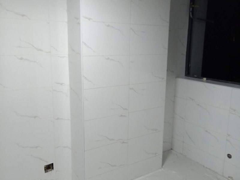 衛(wèi)生間瓷磚鋪貼：基層處理：把沾在基層上的浮漿、落地灰等用暫子或鋼絲刷清理掉，再用掃帚將浮土清掃干凈。找標高：根據(jù)水平標準線和設(shè)計厚度，在四周墻、柱上彈出面層的上平標高控制線。排磚：將房間依照磚的尺寸留縫大小，排出磚的放置位置，并在基層地面彈出十字控制線和分格線。鋪設(shè)結(jié)合層砂漿：鋪設(shè)前應將基底濕潤，并在基底上刷一道素水泥漿或界面結(jié)合劑，隨刷隨鋪設(shè)攪拌均勻的干硬性水泥砂漿。鋪磚時應先在房間中間按照十字線鋪設(shè)十字控制磚，之后按照十字控制磚向四周鋪設(shè)，并隨時用2m靠尺和水平尺檢查平整度。大面積鋪貼時應分段、分部位鋪貼。養(yǎng)護：當磚面層鋪貼完24h內(nèi)應開始澆水養(yǎng)護，養(yǎng)護時間不得小于7d。