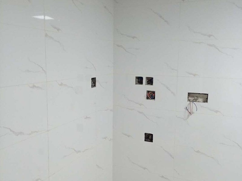 衛(wèi)生間瓷磚鋪貼：基層處理：把沾在基層上的浮漿、落地灰等用暫子或鋼絲刷清理掉，再用掃帚將浮土清掃干凈。找標高：根據(jù)水平標準線和設(shè)計厚度，在四周墻、柱上彈出面層的上平標高控制線。排磚：將房間依照磚的尺寸留縫大小，排出磚的放置位置，并在基層地面彈出十字控制線和分格線。鋪設(shè)結(jié)合層砂漿：鋪設(shè)前應將基底濕潤，并在基底上刷一道素水泥漿或界面結(jié)合劑，隨刷隨鋪設(shè)攪拌均勻的干硬性水泥砂漿。鋪磚時應先在房間中間按照十字線鋪設(shè)十字控制磚，之后按照十字控制磚向四周鋪設(shè)，并隨時用2m靠尺和水平尺檢查平整度。大面積鋪貼時應分段、分部位鋪貼。養(yǎng)護：當磚面層鋪貼完24h內(nèi)應開始澆水養(yǎng)護，養(yǎng)護時間不得小于7d。