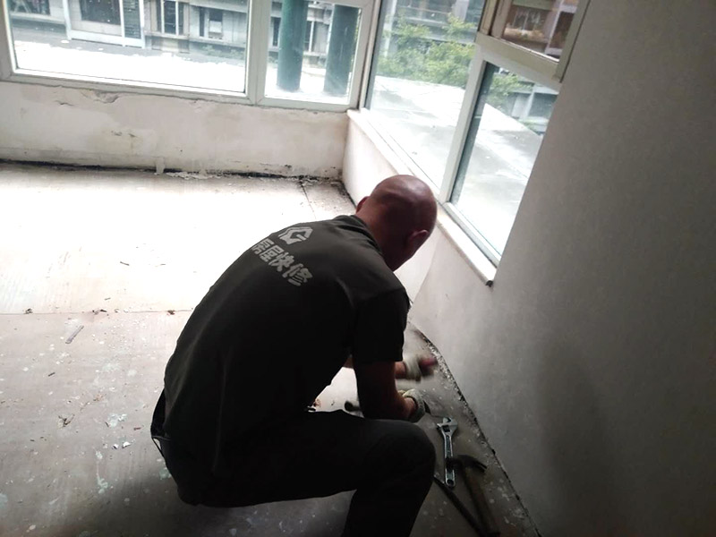 地板拆除維修：復(fù)合木地板拆除工藝比較簡單，清除房間的家具后，使用平口螺絲刀將踢腳線撬開，再沿著踢腳線邊緣將墻角的地板撬開并拆除，這塊地板可能會破損，但是其他地板就可以完整拆除了，帶有鎖扣結(jié)構(gòu)的復(fù)合木地板要順應(yīng)地板的長邊抽出，這樣會比較輕松。拆除后的復(fù)合木地板沒有保留價值，一般都要清運出場最后將鋪至地板下防潮氈揭開，底層可能會有潮濕，這時要開窗通風(fēng)，待地面完全工燥后再鋪設(shè)新地板。 實木地板的拆除工藝比較復(fù)雜，拆除踢腳線后仍從墻角邊緣開始，使用起釘錘將木地板撬起抽出，由于實木地板安裝在木龍骨上，撬起時會有一定的彈性，施工難度較大，但是不能使用切割機，因為切割機容易破壞地面和固定木龍骨的膨脹螺栓而產(chǎn)生火花。