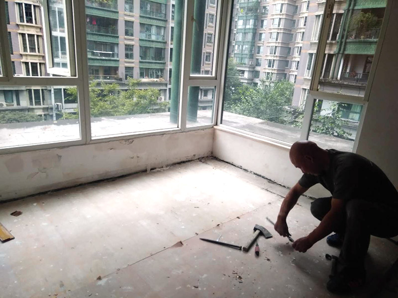 地板拆除維修：復(fù)合木地板拆除工藝比較簡單，清除房間的家具后，使用平口螺絲刀將踢腳線撬開，再沿著踢腳線邊緣將墻角的地板撬開并拆除，這塊地板可能會破損，但是其他地板就可以完整拆除了，帶有鎖扣結(jié)構(gòu)的復(fù)合木地板要順應(yīng)地板的長邊抽出，這樣會比較輕松。拆除后的復(fù)合木地板沒有保留價值，一般都要清運出場最后將鋪至地板下防潮氈揭開，底層可能會有潮濕，這時要開窗通風(fēng)，待地面完全工燥后再鋪設(shè)新地板。 實木地板的拆除工藝比較復(fù)雜，拆除踢腳線后仍從墻角邊緣開始，使用起釘錘將木地板撬起抽出，由于實木地板安裝在木龍骨上，撬起時會有一定的彈性，施工難度較大，但是不能使用切割機，因為切割機容易破壞地面和固定木龍骨的膨脹螺栓而產(chǎn)生火花。