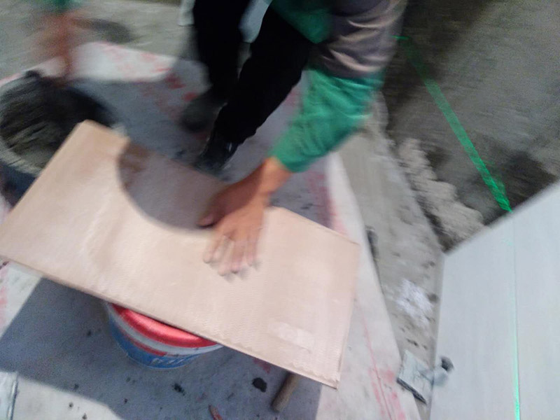 廁所墻面貼瓷磚：廁所貼瓷磚：首先應(yīng)除去基層表面的污垢，油漬，浮灰;除去基層上所有涂料層，膩子層;如果基層未能達(dá)到平整度要求，需對基層進(jìn)行預(yù)先的找平處理；鋪貼瓷磚前需事先找好垂直線，以此為基準(zhǔn)鋪貼的瓷磚高低均勻、垂直美觀；應(yīng)對瓷磚的色彩、紋理、表面平整等進(jìn)行嚴(yán)格的挑選，然后按照圖紙要求預(yù)鋪，調(diào)制粘結(jié)劑；然后將調(diào)制好的漿料均勻地抹在瓷磚背面，要求漿料飽滿，瓷磚平整地鋪貼在基層上，使用橡膠錘將瓷磚拍實鋪平；最后瓷磚鋪貼結(jié)束后24小時，可進(jìn)行嵌縫施工，嵌縫后用浸濕的織物清理多余的嵌縫劑，保持瓷磚表面清潔。