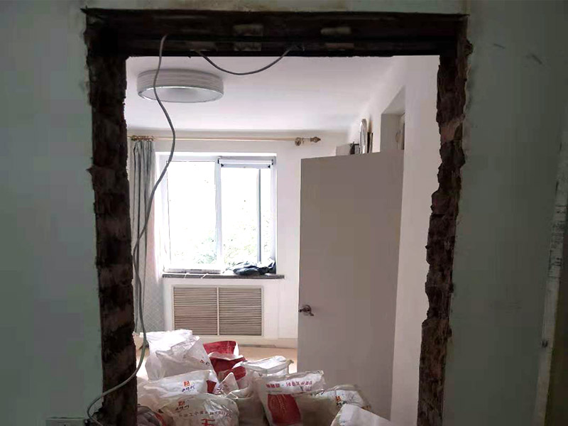 墻面開門洞：把砸去400mm高，寬2340mm的墻，全部用鋼筋混凝土澆筑。內(nèi)配上下各3根直徑12mm的帶肋鋼筋，箍筋直徑6mm，間距200mm，扎好鋼筋放上。支模，注意一側(cè)模板要支成◢形，高度為450，混凝土從該斜口倒入澆筑與斜口平，已高出了圈梁底50mm，即能使其與圈梁底充分咬合。拆模把多余部分鑿除。 應(yīng)在過梁部位先開洞做好過梁，再開門洞，每邊大于100mm，植2根10個(gè)鋼筋交門邊柱作為門垛。鋼筋混凝土過梁在普通磚墻上擱置長度應(yīng)不小于24cm,也就是一磚的厚度，而實(shí)際上門口是38墻，所以過梁一般是38cm； 門洞墻體高建議敲頂部梁面鑿洞再皮皮敲兩邊敲凹凸?fàn)畈孔隽涸倨鲋鎵w直接底洞容易整版墻敲壞松玩且能塌肯定玩洞直接鉆洞。