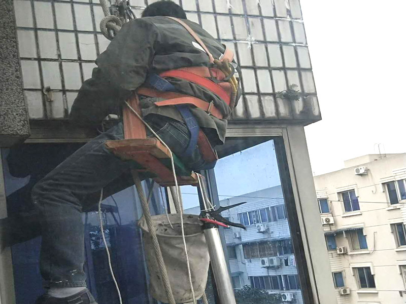 外墻高空維修：1、目前外墻粉刷主要有兩種方式：吊板方式和吊籃方式。 2、吊板方式是用吊繩、吊板將人吊到工作位置進(jìn)行清洗。一般的大樓都可以用這種方式進(jìn)行清洗，但是這種方式的操作必須使安全措施到位，否則危險(xiǎn)性很大，造成傷亡事故的都是因安全措施不到位造成的。 3、對(duì)于無(wú)承載能力、疏松、起皮的舊涂層，應(yīng)連同膩?zhàn)訌氐诅P除，洗凈且干燥后再用膩?zhàn)诱移健?duì)于輕度粉化但牢固的舊涂層打磨平整后用封底漆底涂即可。嚴(yán)重粉化的舊涂層應(yīng)事先徹底清洗，舊的油性涂料應(yīng)完全去除。