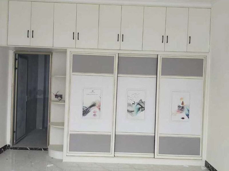 衣柜家具安裝：1.安放底板。衣柜底板放置的地面事先要打掃干凈，因?yàn)榈劝惭b后再去清理的話會非常麻煩。 2.固定框架。按照板材上的凹槽安裝好衣柜的側(cè)板和背板，調(diào)整各塊板之間的位置。 3.安裝頂板。現(xiàn)場最好準(zhǔn)備一個(gè)攀高用的凳子，頂板要舉高了放置上去的，然后用鉚釘固定。 4.安裝擱板。把擱板放置到事先敲好螺絲的地方，然后固定。注意調(diào)整擱板與背板、側(cè)板的固定位置。 5.固定門軌。在衣柜的頂邊和底邊都安裝好門軌，門軌選合金的材料比較好，又輕又牢固。 6.安裝衣桿。在預(yù)留的位置打好固定鉚釘，安裝好衣桿。注意兩邊要平衡。