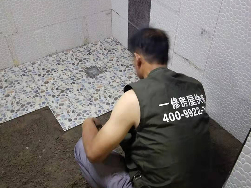 衛(wèi)生間地面花磚鋪貼:找平，就是在鋪仿古磚前，對(duì)鋪貼物表面進(jìn)行處理，如地面、內(nèi)墻面、外墻面等，消除表面附著的污物，并灑水進(jìn)行滋潤，然后用水泥沙混合找平，通常使用灰鏟在表面不停的涂抹使水泥地面保持大致水平，一定要等到水泥沙混合物完全干爽后再行鋪貼。用一段較長的細(xì)線，根據(jù)確定的鋪貼方式，在線上涂上顏色或白灰，然后在找平的地面上畫出仿古磚的位置及磚縫的參考線。 將亞光磚置入清水中浸泡，使瓷磚充分吸收水分，以不冒出氣泡為準(zhǔn)，防止干燥瓷磚在裝修完成后再次吸水而導(dǎo)致磚體變形。取出浸泡好的瓷磚，抹干水漬，在找平層上噴灑足夠的水，然后在磚背面均勻抹上水泥沙漿，沙漿厚度5~6cm為宜，鋪貼大規(guī)格亞光磚時(shí)適當(dāng)加厚；隨即將磚貼上，用木錘輕輕拍牢平整，避免空鼓，并隨時(shí)用直尺找平。