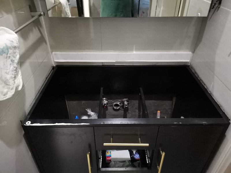 浴室柜安裝：在標(biāo)注好的位置，用氣鉆打孔先安裝主柜；再安裝洗臉盆，用玻璃膠固定好；再安裝水龍頭，接著就是下水器；安裝鏡子，還有置物架；完成。