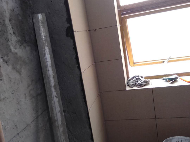 墻面貼磚施工：干鋪法是將沙子和水泥按照3：1的比例混合后兌少量的水，使水泥和沙子混合到可以用手攥成團的黏稠度。將混合好的沙子水泥鋪在地面上，用一個平板把表面摸平。在瓷磚背面抹上黏稠度非常高的水泥，把瓷磚放到地面上，用橡皮錘敲實就完成了,主要用于地面瓷磚的鋪裝。 濕鋪法，是將沙子和水泥按照2：1的比例混合后兌水和好，水的量要多一些，使沙子和水泥的黏稠度高一些。然后涂抹到用水浸泡好的瓷磚背面貼到墻面上。濕鋪發(fā)主要應(yīng)用與墻面。