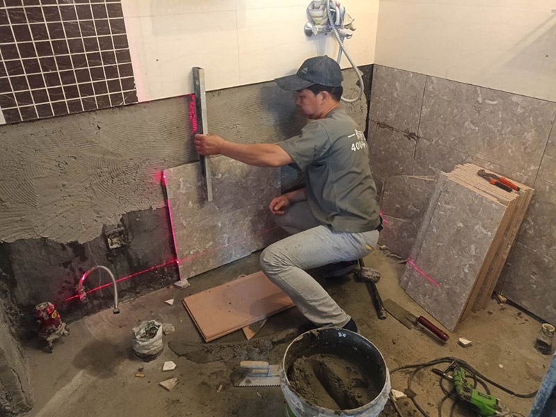 衛(wèi)生間貼磚施工：施工工藝流程; 基層處理--抹底子灰--彈線排磚--侵磚--鑲貼--擦縫--交工驗收 用一比三的水泥砂漿打底,打底厚度5~~7mm，待底子灰干六七成干時候，按圖紙要求，進行彈線，排磚。立好皮數(shù)桿，排磚形式有主要兩種直縫和錯縫。當?shù)孛嬗蟹核臅r候，注意安排好泛水。侵泡瓷磚，時間不少于兩個小時，陰干通常是3~~5小時。瓷磚在鑲貼時候，瓷磚下口坐在八字尺或直尺上。鋪貼的方式有離縫和無縫。鑲貼瓷磚從陽角開始，自下向上貼，瓷磚背面刀灰，貼上用力壓，用鏟刀木柄輕輕敲打，鋪貼時候砂漿飽滿，缺灰重貼，不得塞灰，貼6~~8塊，用靠尺校正。水管處先鋪周圍整塊磚，后鋪異型磚。最后擦縫。