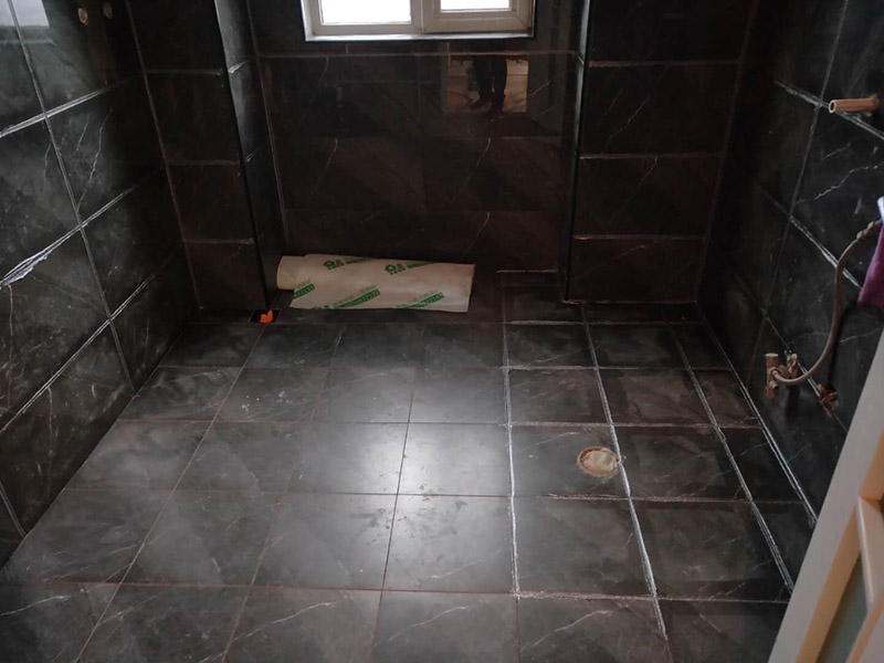 衛(wèi)生間美縫施工：使用用開槽器/平口螺絲刀/勾縫刀，清理瓷磚縫隙內(nèi)灰塵及垃圾，這一步需要力度適中，不要用蠻力，不然可能存在崩壞瓷磚的風險。然后用吸塵器，掃把或者抹布清理干凈。，建議縫隙在1.5到2mm深度合適?？p隙清理干凈后， 擰開管蓋裝上混合管，管頭卡在膠槍的卡口上。裝好混合管后，從下方用美工刀斜切45度角，切記開口要比瓷磚縫隙小，如果本身瓷磚縫隙比較小，可以不用切膠嘴。首先打出30-40CM美縫劑余料，然后沿著瓷磚縫隙開始施工，在施工的時候一定要美縫劑填充滿瓷磚縫隙，不然后續(xù)可能會發(fā)生塌陷。瓷磚縫隙打膠方法先豎后橫，沿著縫隙均勻打出美縫劑.一般有些師傅打出3-5米時停下，開始用壓邊球壓縫，十字交叉口處多壓幾次，這樣會很美觀。壓縫的工具比較多，可用刮板或者壓縫 鋼球、手指套沿著縫隙壓出 U型面就可以了