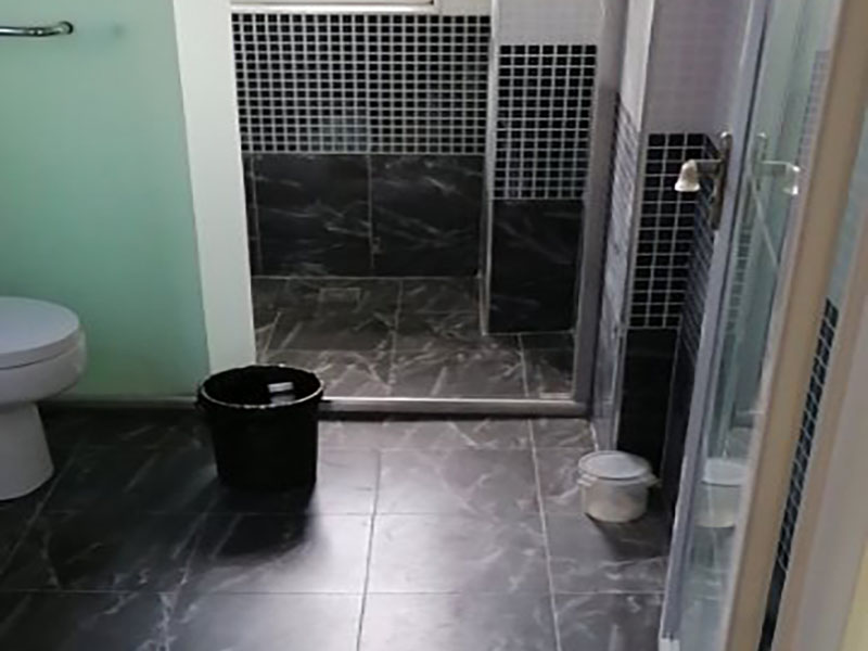 浴室防水貼磚裝修：一是墻磚應(yīng)從下向上鋪貼,且一面墻不能一次貼到頂,接縫一般為1~3毫米; 二是鋪貼前要先處理墻面的平整,處理裂縫; 三是粘結(jié)材料的涂抹要中間稍高于四周,用橡膠錘敲擊表面以固定,這樣一來(lái)可以避免空氣積存于粘結(jié)層中。同時(shí)要進(jìn)行水平檢測(cè); 四是粘結(jié)材料要挑和適當(dāng),一般墻面水泥與沙比例為1:4,地面水泥與沙比例為1:32. 地面要打平。有一些土建地面是不平的,遇到這種情況大家應(yīng)該把不平的地方用水泥沙漿鋪平。鋪設(shè)時(shí)可以用不同的色彩的瓷磚(較深色的)把周?chē)蚱饋?lái),而框內(nèi)的瓷磚用較淺色的。當(dāng)然,廚房跟廁所的地面一定要有傾斜度,這樣是為了方便排水