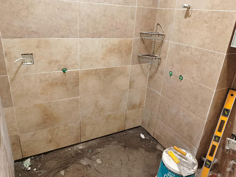 衛(wèi)生間瓷磚鋪貼：基層處理--抹底子灰--彈線排磚--侵磚--鑲貼--擦縫--交工驗(yàn)收 首先進(jìn)行地面清掃，不打掃干凈會(huì)翹邊、空鼓的;放水平du線然后分塊;地面要濕潤(rùn)進(jìn)行灑水;采用兩種砂漿，打砂漿的基層，一般要進(jìn)行干鋪;地磚是不是出現(xiàn)了空鼓是很重要的;還要在磚底涂抹上漿;鋪貼的時(shí)候要用橡皮錘敲擊，做拉縫、表面清理，對(duì)瓷磚進(jìn)行勾縫處理即可。最重要的是保護(hù)好成品，以防造成污染和損傷。