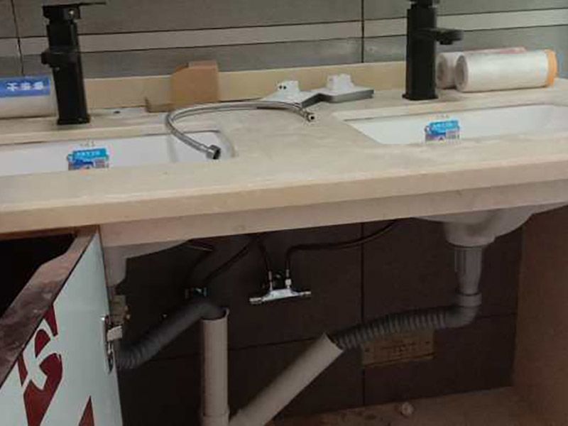 臺盆五金安裝：1.檢查預(yù)留給排水管路，安裝支撐洗面盆臺面的鋼制支架。 2.根據(jù)臺下盆包裝箱內(nèi)的臺面切割圖將臺面開孔打磨完畢。 3.按照安裝的龍頭和臺面尺寸正確切割龍頭安裝孔，打磨。 4.把洗面盆暫時放入已開好的臺面安裝口內(nèi)，檢查間隙，并做好記號。 5.檢查校驗后，把洗面盆放平，在洗臉盆邊緣上口涂上硅膠密封材料后，把洗面盆小心放入臺面下，對準(zhǔn)安裝孔，跟先前的記號相校準(zhǔn)并向上壓緊，并使用廠家隨貨附帶的臉盆與臺面的連接件，將洗臉盆與臺面緊密連接。 6.臺下盆邊緣打膠。 7.安裝臺下盆上下五金件。 8.等密封膠硬化后，連接進水和排水管件。