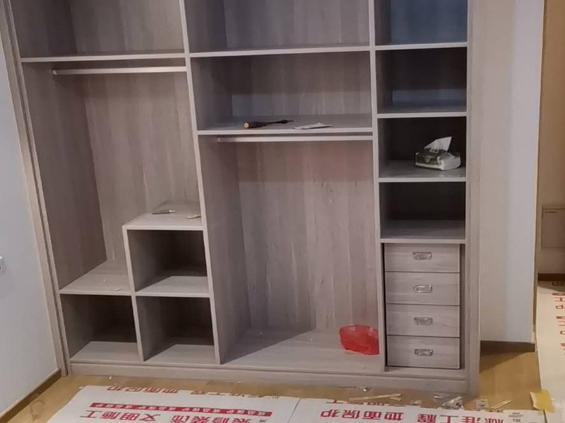 家具柜體安裝：用墊布點好地板，先從靠墻的一端寬du側(cè)板開始組裝，將寬側(cè)板平放于地面上(離后墻面保持700mm間隔)。首先將填好的三合一膠塞的板件，平放在墊布上，檢查孔距與圖紙相符，并裝上三合一單連桿。然后將固層釘上木塞，固定于寬側(cè)板上面，頂板大柄孔朝上，其余固層都朝下，腳線大柄孔朝內(nèi)(中間固層與L架高度一致，即底板到固層內(nèi)空為960mm，現(xiàn)場打?qū)影蹇?。放上側(cè)板，釘上木塞，木塞要求連通兩邊的固層。在第二個柜固層上面裝好雙連桿，留意雙連桿上面大柄只能鎖住一半，即90°。當兩件固層與側(cè)板固定后再同時擰緊大柄。 釘背板：把裝好的整體柜側(cè)放在點好墊布的地板上面，墊平側(cè)板成統(tǒng)一平面。用拉尺量好柜子的對角尺寸，調(diào)至相等，從寬測板處開始裝第一塊背板，留意假如中間有固層釘釘子時，先用鉛筆畫好固層的中央線，再釘釘子。