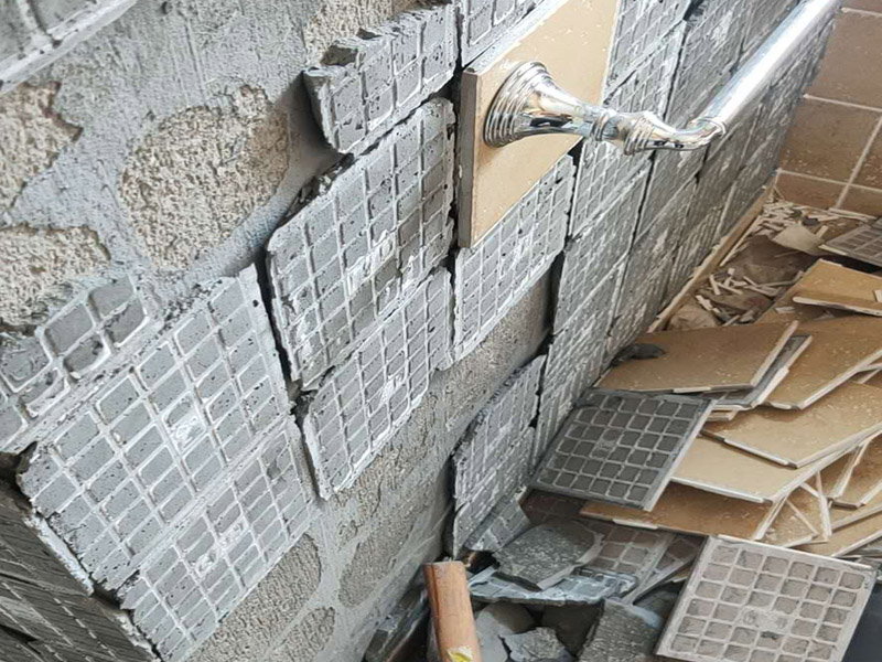 瓷磚空鼓脫落鋪貼:將挑選好的瓷磚浸泡在水盆里，浸泡時間按瓷磚的密度而定，以水盆里不出水泡為好，說明瓷磚內(nèi)部已無空氣。瓷磚泡好后，將瓷磚從水盆里拿出來，瀝瀝水，瓷磚有水較滑，動作要輕巧小心，以免瓷磚滑落摔破。晾干后，瓷磚鋪貼平整，也要求墻壁本身要平整，用直尺在毛坯房墻面找平。將801膠水與水按1：5的比例調(diào)配，膠水取代傳統(tǒng)的黃沙讓泥漿更有粘性。墻面如果有不平整的地方，用鏟刀修理平整，再用直尺檢測全部平整才合格。在墻壁上涂一層防水涂料，以防止衛(wèi)浴間的水汽滲進墻壁。這個步驟很重要，一定不可省略。