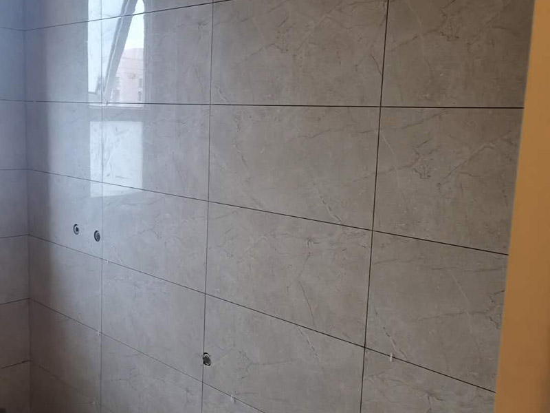 地磚墻磚鋪貼方案：在鋪貼墻磚之前，需要對(duì)其進(jìn)行基層處理。先將基層表面的灰塵和污漬清理干凈，然后在將其表面的膩?zhàn)訉雍屯苛蠈尤コ蓛?。同時(shí)，還應(yīng)對(duì)基層的平整度進(jìn)行檢查，如果基層不平，則還需要用水泥砂漿找平，否則會(huì)影響墻磚的鋪貼效果。基層清理干凈后，還不能直接鋪設(shè)墻磚，而是要先在墻體四周用墨線彈出幾條標(biāo)高控制線，并在地面彈出十字線，控制好每塊地磚的尺寸。調(diào)制好粘結(jié)劑之后，就可以開始準(zhǔn)備鋪貼墻磚了。在鋪貼前，要對(duì)墻磚產(chǎn)品表面的灰塵和污垢進(jìn)行清理。處理干凈后，便可將事先配置好的漿料涂抹在瓷磚背面，注意在涂抹漿料的時(shí)候要涂的均勻和飽滿。將涂抹了漿料的墻磚按照之前預(yù)鋪的花紋樣式進(jìn)行鋪貼，鋪貼平整之后，再用橡膠錘子將其拍平鋪實(shí)，增強(qiáng)其穩(wěn)定性。同時(shí)，在這個(gè)過程中，還可稍微的轉(zhuǎn)動(dòng)一下墻磚，讓瓷磚背面與漿料充分接觸，緊密融合。