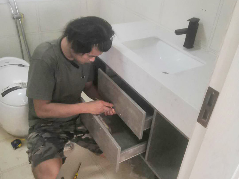 浴室柜及燈具安裝：安裝前，檢查零配件是否齊全。安裝三角閥，確保冷熱進(jìn)水管保持齊平。測量距離，安裝下水管。涂抹膠水要均勻，確保管與管間連接緊密。安裝柜角，看所有角是否在同一水平。裝好后可做適當(dāng)?shù)恼{(diào)整。將浴室柜靠墻放好?？催M(jìn)出水管位置是否得當(dāng)，不合適時需做一定改動。安裝臺盆的龍頭。龍頭最好與浴室柜配套購買，這樣出水角度較為適合。用螺母固定臺盆龍頭。固定時一只手要扶好龍頭，以免裝好后位置偏離。將裝好龍頭的臺盆放在浴室柜上，調(diào)整位置到最佳為止。連接臺盆的進(jìn)出水管及下水，長度適當(dāng)，位置合理。裝好柜體的把手，并進(jìn)行適