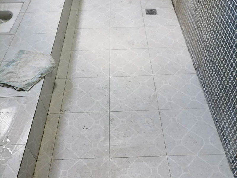 公共衛(wèi)生間貼磚施工：清理墻面上的各類污物，打掃干凈現(xiàn)場，特別是腳落里。用泥刀先批墻，后用水泥漿找平。這個工序很重要，確保底子平，防止貼后空鼓。墻面要刷防水涂料，防止貼后浸水，一般高度不低于1.8米，刷的時候會稍高一些。瓷磚上墻將經(jīng)過預先清潔的瓷磚平整地鋪貼在粘結劑漿料基層上，使用橡膠錘將瓷磚拍實鋪平。施工過程中，可小幅度轉動瓷磚，使?jié){料與瓷磚背面充分接觸。留縫大小調整根據(jù)瓷磚的尺寸，在磚與磚之間預留相應尺寸的縫隙留待嵌縫?？捎醚篮灥认裙潭?，粘結劑具有一定的可調整性，可對留縫的大小進行調整。