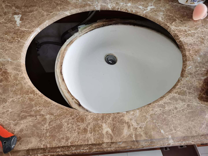 洗臉盆脫落維修:陶瓷臉盆下邊必須用架子托住，與石材臺板用普通玻璃膠密封，這樣臺板和臉盆就允許發(fā)生一定的相對位移，封膠的目的是不漏水，絕對不能用結(jié)構(gòu)膠把臉盆與臺板粘死靠膠來承受陶瓷臉盆的重量；應(yīng)該靠下面的托架托住陶瓷臉盆；否則一旦盆中放滿熱水，盆體受熱膨脹，而盆邊與臺板粘死不能變形，巨大的內(nèi)應(yīng)力就會損壞陶瓷臉盆，嚴重時就會掉底。