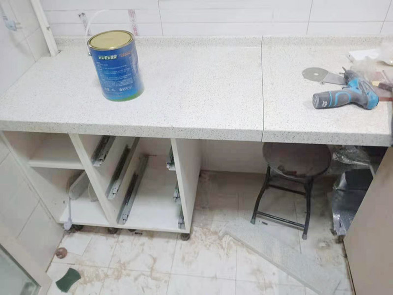 櫥柜維修改造：對廚房作防護措施,掛擋布、廚房墻面等做簡單清理,以便準確測量地面水平。 材料進場:櫥柜板材等進場。  安裝地柜 組裝:統(tǒng)一組裝好地柜,搬進廚房,按圖紙順序擺放好位置(倒放),統(tǒng)一安裝地腳。 現(xiàn)場切割:地面上墊上保護物,割口根據(jù)實物的大小從反面進行操作,保持正面不崩。 安裝順序：如有轉(zhuǎn)角柜應先安轉(zhuǎn)角柜，沒有轉(zhuǎn)角柜先從靠墻的柜往外安裝。 水平調(diào)整：通過地柜的調(diào)節(jié)腿調(diào)節(jié)地柜水平度，誤差保持正負1mm。