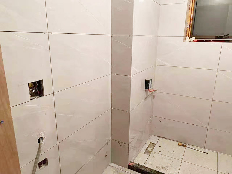 衛(wèi)生間貼磚施工：衛(wèi)生間貼磚要先將所需材料準(zhǔn)備好，一般用在這個(gè)空間的話可以選擇小瓷磚，例如小方塊類(lèi)型的瓷磚就不錯(cuò)，貼起來(lái)也比較方便。然后將水泥與建筑膠混合拌勻，用鏟刀將其鏟到地面刮平再將瓷磚鋪上刀壓實(shí)，這樣按照這樣的方式自上而下或自左而右來(lái)進(jìn)行貼磚即可。