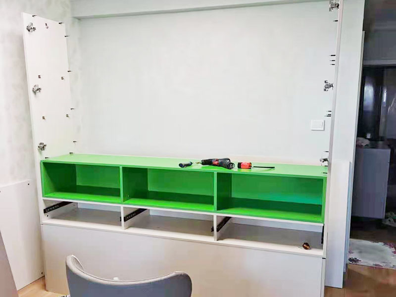 衣柜組裝施工：第一步要把柜體安裝好?？梢韵劝压褡幼髠?cè)的木板放在地上，在有膠的孔上面打上螺桿，然后把背拉條和螺桿固定在一起，要鎖上鎖柄。接著需要把頂板安裝上去，這樣一看是不是衣柜大概有了簡單的樣子呢?接下來就要安裝底板了，在底板上安裝上螺桿，固定好角條了以后，就把之前已經(jīng)組裝好的頂板和底板組裝到一起，要是中間有不會的就要參考實木衣柜安裝步驟圖，用處還是很大的，那么實木衣柜的外邊基本上就差不多了。 下面就要組裝褲架和抽屜了。在開始的時候可以先把實木衣柜的褲架和抽屜拿出來放在一邊，先將抽屜側(cè)面安上螺桿，把安裝