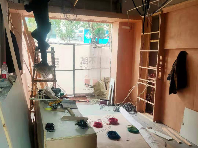門店木工施工現(xiàn)場:首先應(yīng)該搭建木作施工臺。木作施工臺用于板材的切割板，板材的造型，板材的平整度處理等等。門窗的制作包括門窗套制作、門窗制作。要特別注意門窗扇與框之間的縫隙不能太大，以及門窗套與門窗的色差等。木作表層封裝木制品制作完成后，對其表面進(jìn)行細(xì)節(jié)封裝。木作表層封裝通常就要用到各種各樣的家裝板材，特別注意板材的選購。