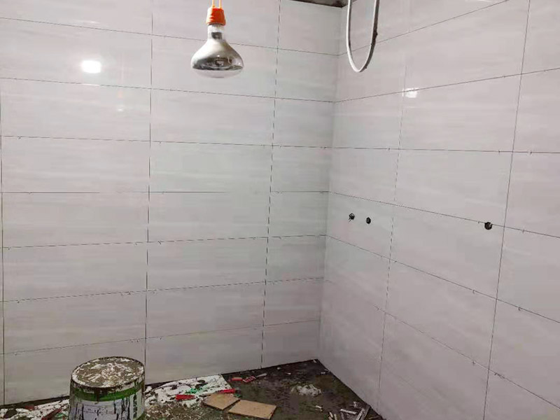 浴室貼磚裝修:把還沒有涂抹水泥的地磚鋪在地上，把它們敲平，然后在地磚上涂滿水泥，鋪在地面，保持四塊磚的對(duì)角位置對(duì)齊。 鋪瓷磚的順序其實(shí)也是有不少講究的，鋪地磚的時(shí)候應(yīng)該從內(nèi)向外貼，遇到坡度或者有地漏的地方，還要注意排水方向找坡；墻面磚的鋪貼應(yīng)該從下向上進(jìn)行。為了最后的鋪貼效果美觀，最底層的瓷磚要最后貼；墻面磚鋪貼結(jié)束以后還要壓地磚。 這里要注意的是，貼瓷磚的時(shí)候不能一面墻貼到頂，否則由于瓷磚較重容易引起脫落。鋪好了地磚盡量不要去踩。 因?yàn)榇纱u本身有許多小孔，吸水能力強(qiáng)，干燥的瓷磚會(huì)吸干水泥的水分.