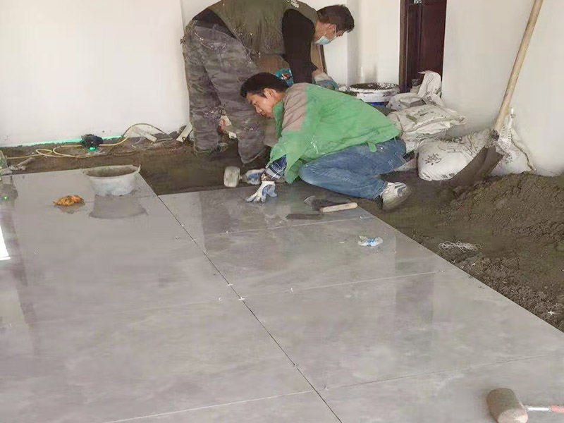 客廳地面貼磚：首先要把基層用水澆濕，除去雜物和浮沙。再抹結(jié)合層，需要注意的是要使用1：3的干性水泥漿，按照水平線(xiàn)探鋪平整，然后再把磚放在沙漿上用膠皮錘振實(shí)。這時(shí)再把地面磚取下澆抹水泥漿，然后把地面磚放實(shí)振平就可以了。采用干鋪法可以有效地避免鋪裝過(guò)程中造成的空鼓、氣泡等現(xiàn)象發(fā)生。但是干鋪法的技術(shù)含量比較高，所以費(fèi)用也會(huì)比較貴。