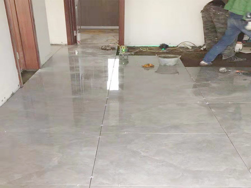 客廳地面貼磚：首先要把基層用水澆濕，除去雜物和浮沙。再抹結(jié)合層，需要注意的是要使用1：3的干性水泥漿，按照水平線(xiàn)探鋪平整，然后再把磚放在沙漿上用膠皮錘振實(shí)。這時(shí)再把地面磚取下澆抹水泥漿，然后把地面磚放實(shí)振平就可以了。采用干鋪法可以有效地避免鋪裝過(guò)程中造成的空鼓、氣泡等現(xiàn)象發(fā)生。但是干鋪法的技術(shù)含量比較高，所以費(fèi)用也會(huì)比較貴。