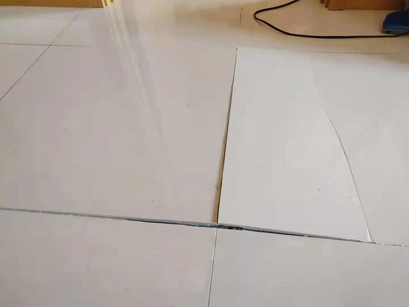 客廳地磚起翹修復：將油灰刀的邊緣滑入松散的瓷磚與其旁邊的瓷磚之間的接縫中。撬起瓷磚并將其移除。用金屬刮刀或小的撬桿的平坦邊緣刮掉基材和瓷磚背面的稀釋劑或瓷磚粘合劑。用相同的工具刮擦周圍空間的舊水泥漿。用清水沖洗除去翹起的瓷磚，然后用濕海綿擦拭，使其干凈。將砂漿抹在缺口邊緣上，然后將稀釋水泥砂漿抹在瓷磚的背面，將瓷磚鋪回原位。如果難以將瓷磚平整，則將瓷磚墊片插入接縫或修補物與包圍它的瓷磚之間的接縫或接縫中。刮掉多余的漿液，并讓該區(qū)域靜置約10分鐘。用水蘸軟海綿，然后輕輕擦拭修復區(qū)域。瓷磚上出現(xiàn)一層干粉后，請用干抹布擦拭。