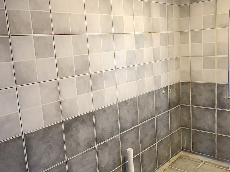 衛(wèi)生間墻磚鋪貼：首先應(yīng)除去基層表面的污垢，油漬，浮灰;除去基層上所有涂料層，膩?zhàn)訉?如果基層未能達(dá)到平整度要求，需對(duì)基層進(jìn)行預(yù)先的找平處理。鋪貼瓷磚前需事先找好垂直線，以此為基準(zhǔn)鋪貼的瓷磚高低均勻、垂直美觀;此外，施工前在墻體四周需彈出標(biāo)高控制線，在地面彈出十字線，以控制地磚分隔尺寸。調(diào)制粘結(jié)劑：加水后將粘結(jié)劑漿料攪拌至潤(rùn)滑均勻，無(wú)明顯塊狀或糊狀結(jié)塊，攪拌后的漿料靜置5-10分鐘后再稍加攪拌1-2分鐘即可使用。 將瓷磚平整地鋪貼在基層上，使用橡膠錘將瓷磚拍實(shí)鋪平。施工過程中，可小幅度轉(zhuǎn)動(dòng)瓷磚，使?jié){料與瓷磚背面充分接觸。