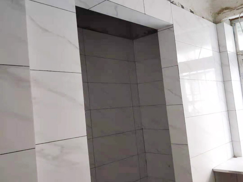 廚衛(wèi)瓷磚鋪貼案例：衛(wèi)生間、廚房的瓷磚鋪貼與客廳一樣，檢查是否平整，敲擊有無空鼓，縫隙不大且平均整齊，特別是四塊磚的角在一起的地方是否平整。 陽角處一定要碰角（各45度合在一起呈90度）鋪裝。 要注意的是廚衛(wèi)地磚要有往地漏傾斜的坡度，檢查水能不能往哪里流動。而且地磚要低于相連的其他地面。